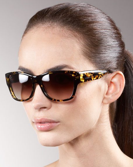 A woman wearing sunglasses with a ponytail.